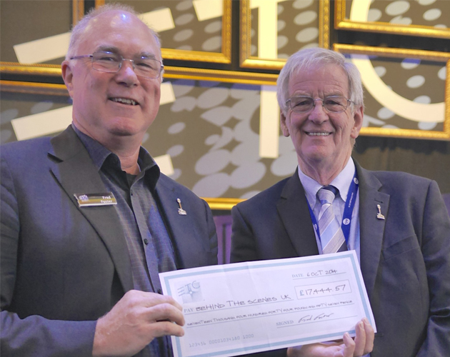 ETC CEO Fred Foster gives a check to Behind the Scenes Trustee John Simpson at the 2014 PLASA tradeshow